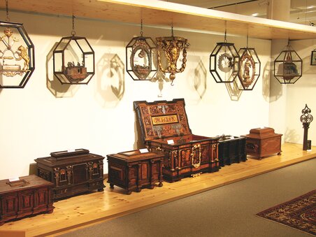 Various antique furniture and decorative pieces in an exhibition. | © Schell Collection