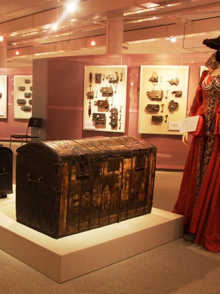 Historical chests and costumes in an exhibition. | © Schell Collection