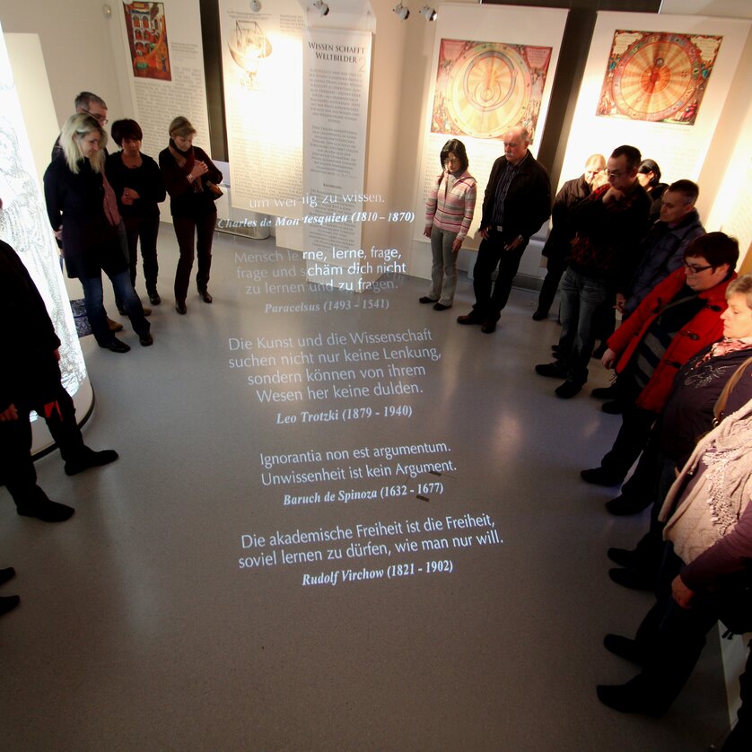 Besucher im Museum hören Zitate über Wissenschaft und Freiheit projiziert auf den Boden. | © UniGraz@Museum
