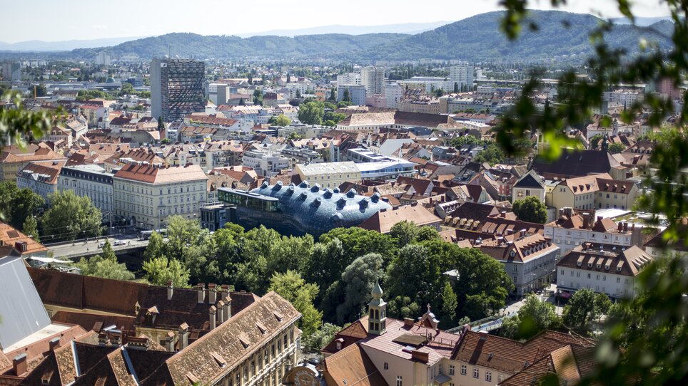 Blick auf Graz mit traditionellen Dächern und dem Kunsthaus Graz. | © Graz Tourismus - Tom Lamm