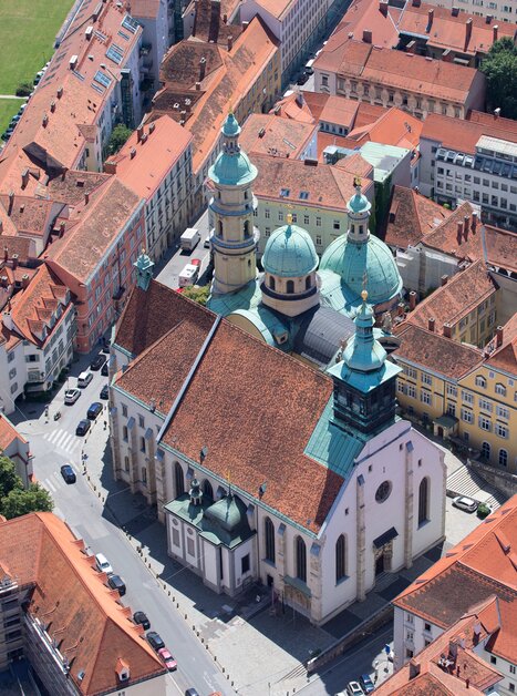 Aerial view of the Cathedral of Graz, surrounded by red roofs. | © Graz Tourismus - Harry Schiffer