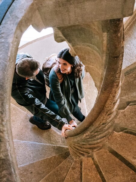 A couple holding hands on the Double Spiral Staircase in Graz. | © Graz Tourismus