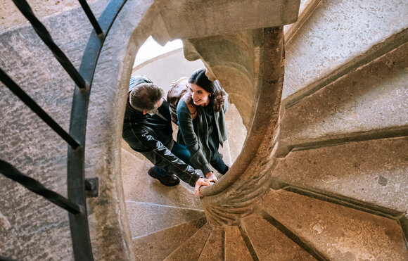 A couple holding hands on the Double Spiral Staircase in Graz. | © Graz Tourismus