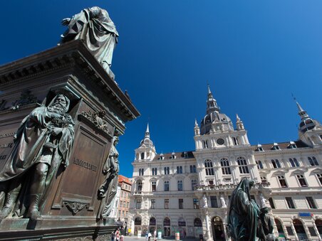 View of the town hall at Hauptplatz in Graz with statues in the foreground. | © Graz Tourismus - Harry Schiffer