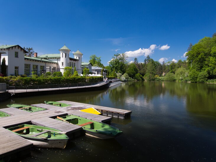 Vista splendida del Hilmteich a Graz con molo per barche e vegetazione lussureggiante. | © Graz Tourismus - Harry Schiffer