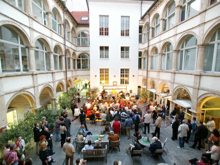 Belebter Innenhof mit Menschen und einer Band bei einem Event im Generalihof. | © Graz Tourismus - Harry Schiffer