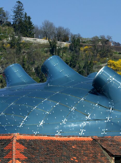 Moderne Architektur des Kunsthauses Graz mit Grazer Uhrturm im Hintergrund. | © Graz Tourismus - Harry Schiffer