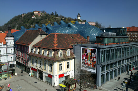 Vista del Kunsthaus Graz e della Torre dell'Orologio di Graz. | © Graz Tourismus - Harry Schiffer
