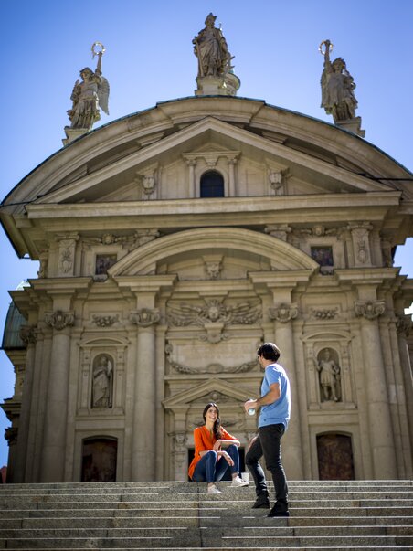 Paar sitzt auf Treppen vor dem beeindruckenden Mausoleum in Graz. | © Graz Tourismus - Tom Lamm