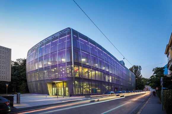 The MUMUTH in Graz is a modern building with a glass facade at dusk. | © Wolfgang Hummer