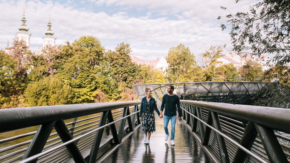 Couple walking on the Island in the Mur in Graz along the Mur. | © Graz Tourismus