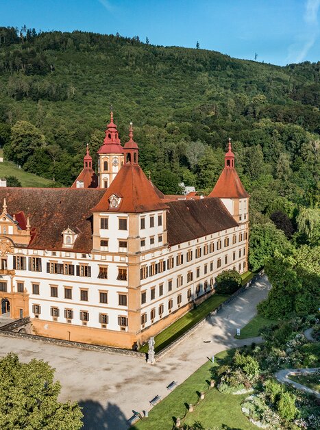 Aerial view of Eggenberg Palace in Graz, surrounded by green landscape. | © Graz Tourismus - Mias Photoart