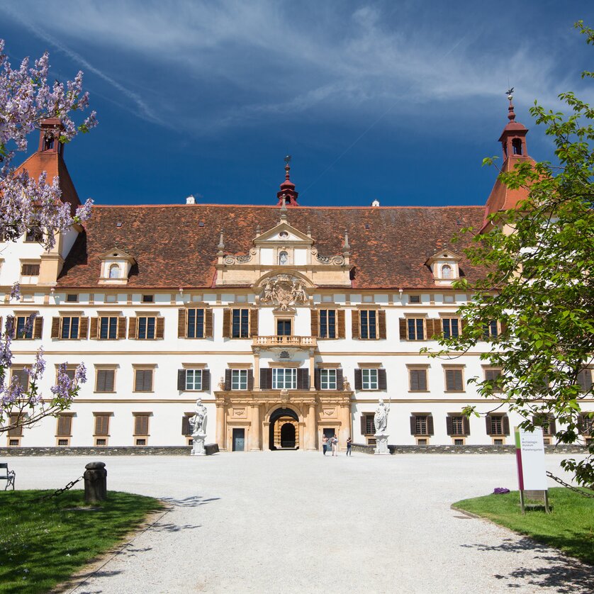 Das prächtige Schloss Eggenberg in Graz, umgeben von Blumen und Bäumen. | © Graz Tourismus - Harry Schiffer