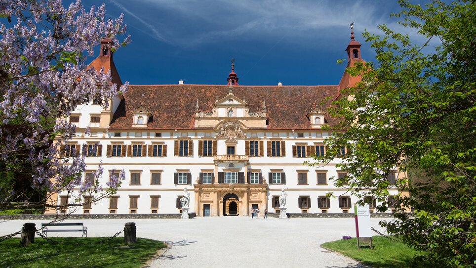 Das prächtige Schloss Eggenberg in Graz, umgeben von Blumen und Bäumen. | © Graz Tourismus - Harry Schiffer