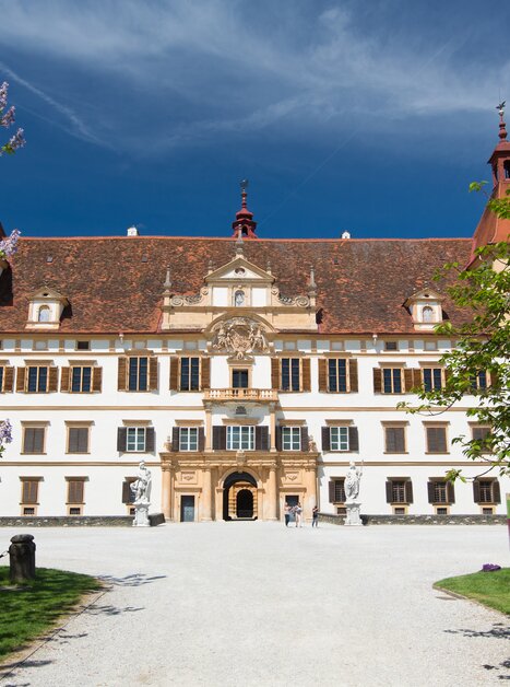 Das prächtige Schloss Eggenberg in Graz, umgeben von Blumen und Bäumen. | © Graz Tourismus - Harry Schiffer