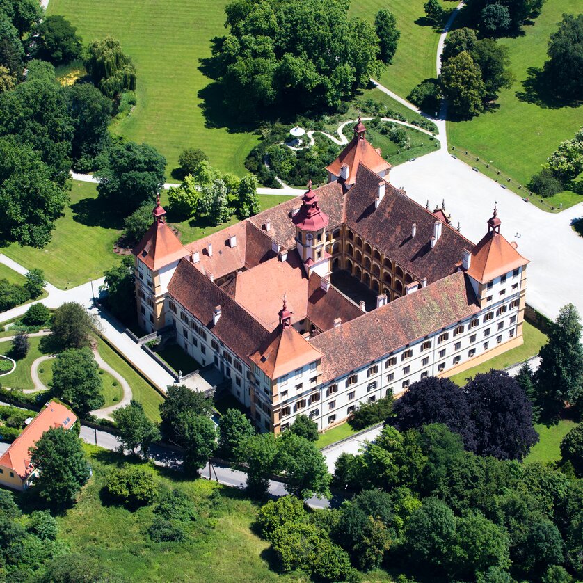 Aerial view of Eggenberg Palace surrounded by lush gardens. | © Graz Tourismus - Harry Schiffer