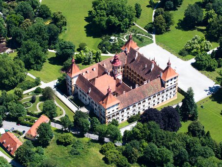 Aerial view of Eggenberg Palace surrounded by lush gardens. | © Graz Tourismus - Harry Schiffer