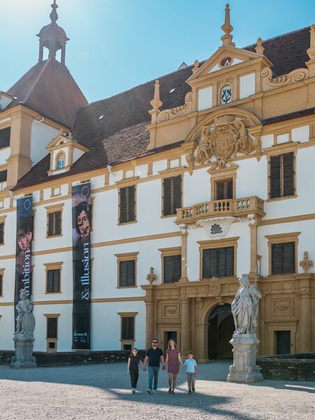 Visitors in front of a creative castle featuring large banners. | © Graz Tourismus - Mias Photoart