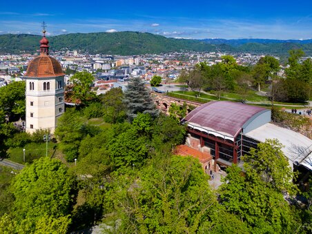 Blick auf den Glockenturm und die Kasematten am Grazer Schlossberg mit Stadtansicht. | © Graz Tourismus - Harry Schiffer
