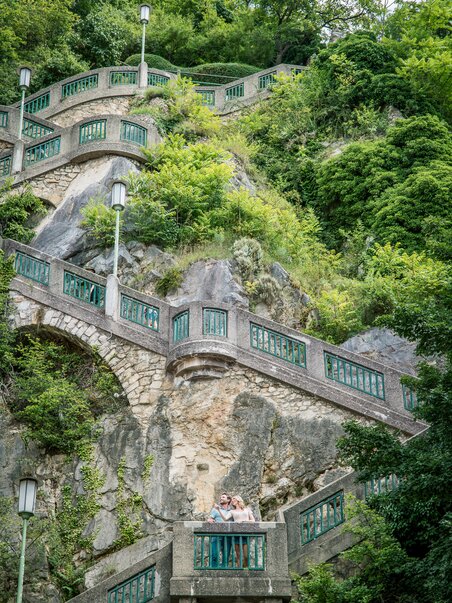 Zwei Personen auf dem Schlossbergsteig in Graz umgeben von Grün. | © Graz Tourismus - Mias Photoart