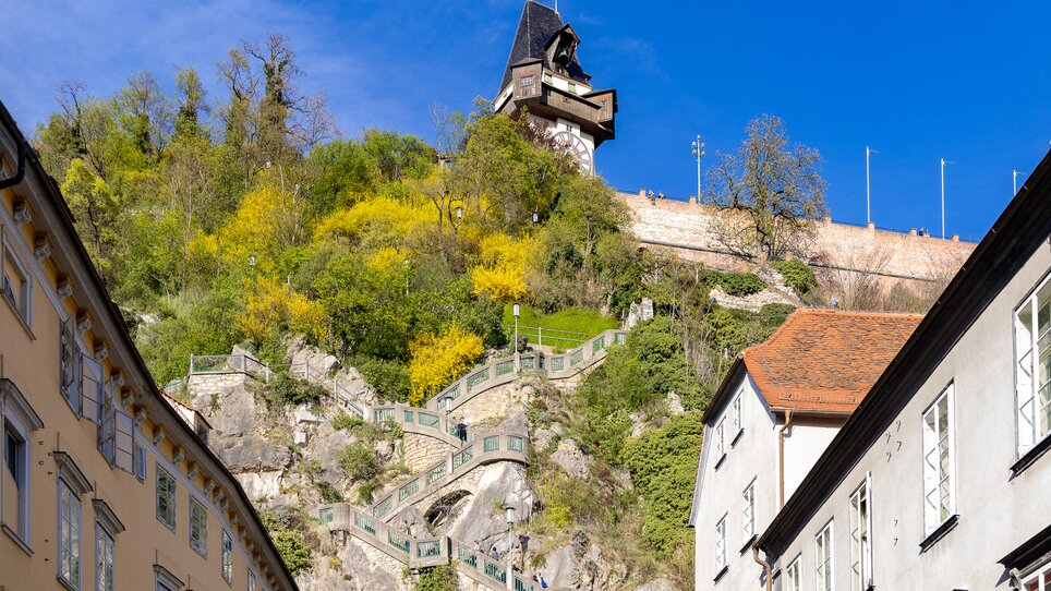 Der Grazer Uhrturm oberhalb der Stadt Graz mit dem Schlossbergsteig. | © Graz Tourismus - Harry Schiffer
