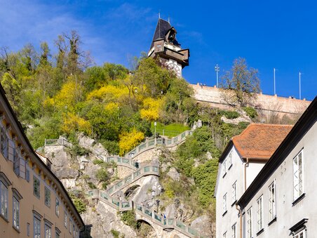 Der Grazer Uhrturm oberhalb der Stadt Graz mit dem Schlossbergsteig. | © Graz Tourismus - Harry Schiffer