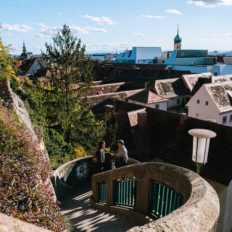 View of Graz from the Schlossbergsteig with a picturesque rooftop landscape. | © Graz Tourismus