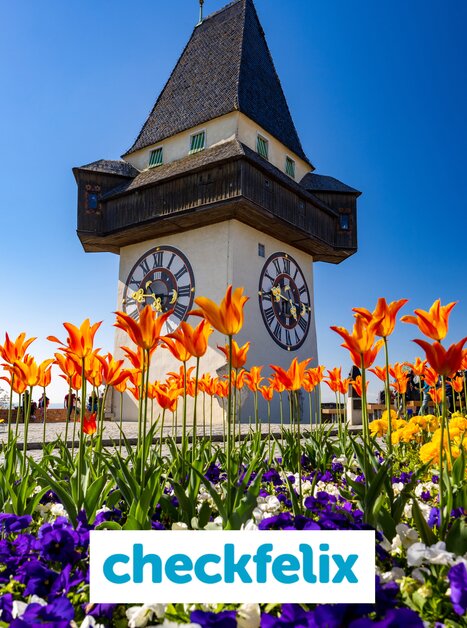 Der Uhrturm am Grazer Schlossberg mit bunten Blumen im Vordergrund. | © Graz Tourismus - Harry Schiffer (9) Kopie