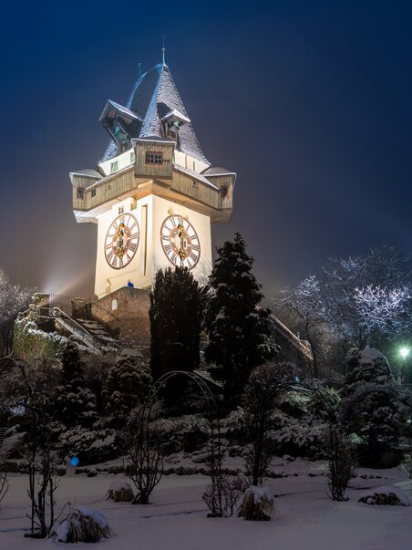 Beleuchteter Uhrturm auf dem Grazer Schlossberg im Schnee. | © Graz Tourismus - Harry Schiffer