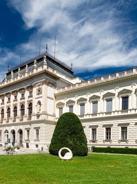 View of the Karl Franzens University of Graz with green lawn and blue sky.
 | © Graz Tourismus - Harry Schiffer