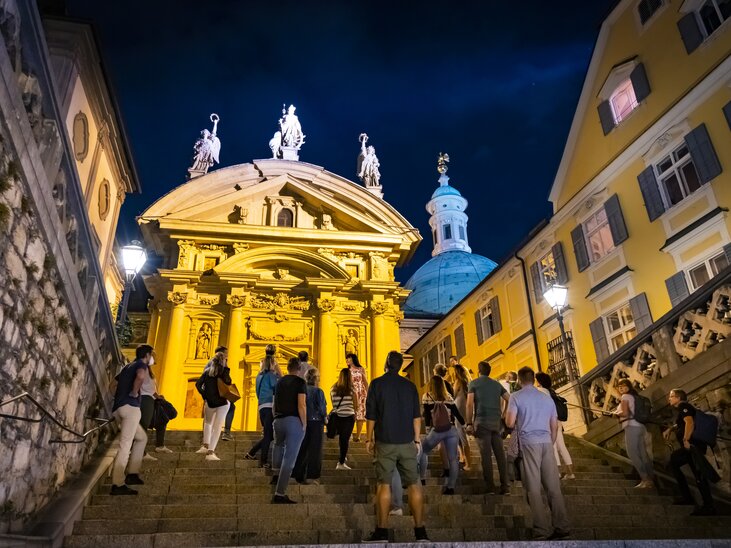 Touristen auf einem geführten Abend-Rundgang in Graz vor dem Mausoleum. | © Graz Tourismus - Werner Krug