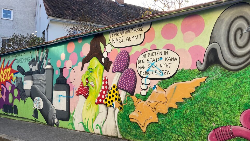 Graffiti mit Figuren, Pilzen und Comic-Texten in Graz. | © Graz Tourismus - NA