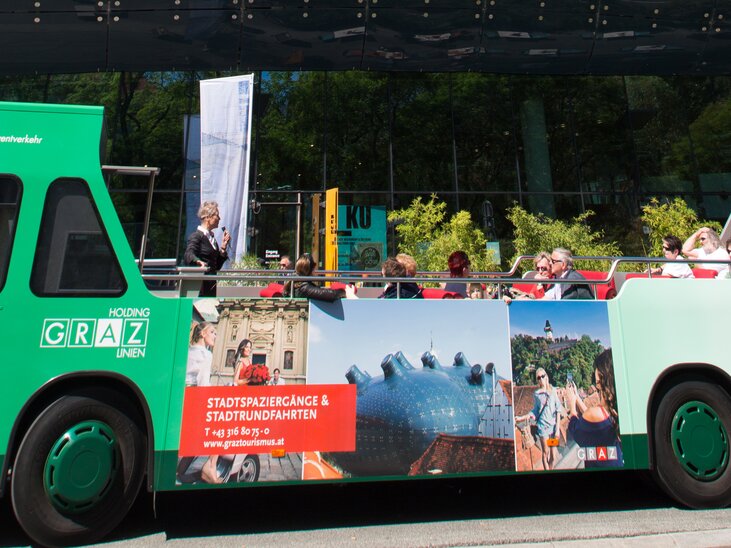 Una tour della città con il cabriobus a Graz, con turisti e l'area circostante. | © Graz Tourismus - Harry Schiffer