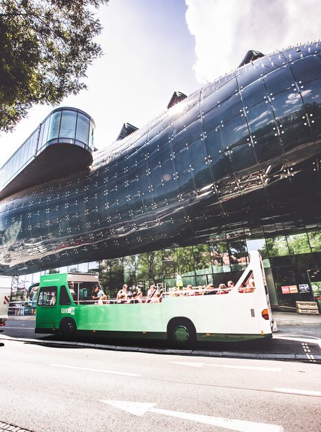 Ein offener Cabriobus steht vor dem Kunsthaus in Graz. | © Lupi Spuma