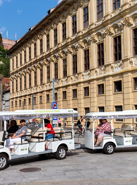 An electric shuttle on a city tour in Graz, with passengers on board. | © Graz Tourismus - Harry Schiffer