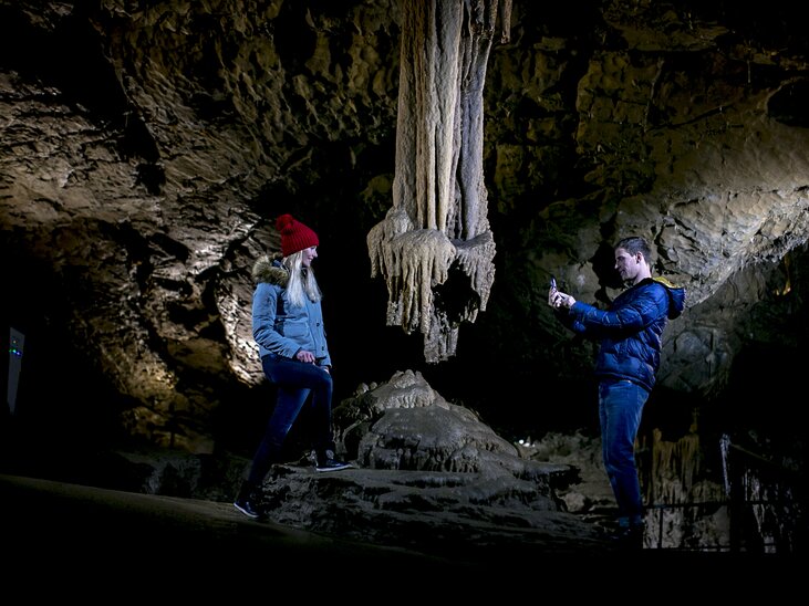Two people exploring Lurgrotte Peggau, photographing stalactites. | © Region Graz - Tom Lamm