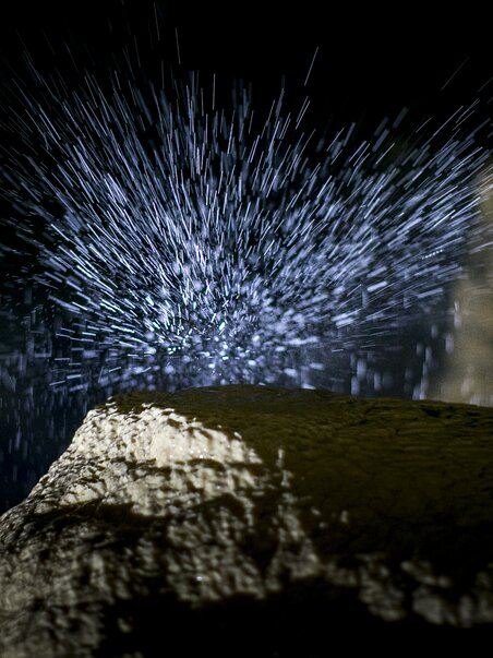 Spritzendes Wasser in der Lurgrotte Semriach über einem Felsen. | © Region Graz - Tom Lamm