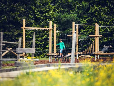 Ein Junge spielt auf einem Klettergerüst in einem Spielplatzumfeld. | © Lupi Spuma