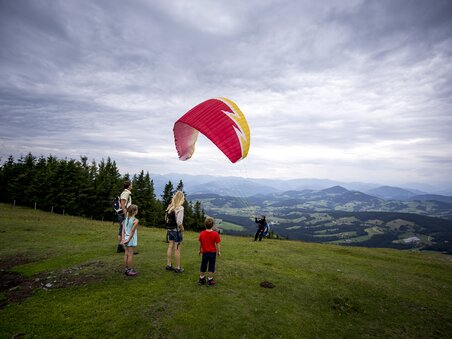 Children watching a paraglider on Schoeckl. | © Region Graz - Tom Lamm
