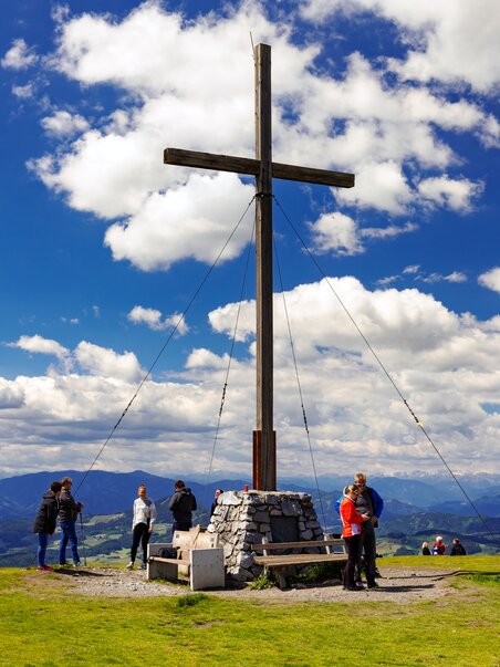 Hikers on Schöckl, overlooking the mountain cross and landscape. | © Region Graz - Harry Schiffer