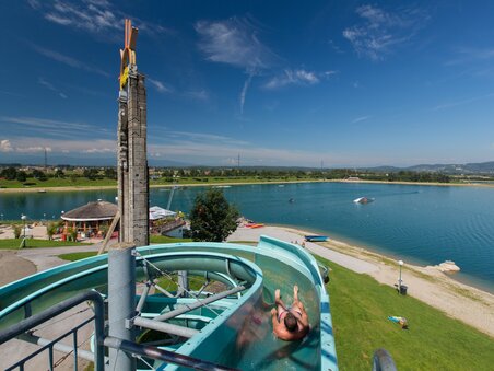 Ein Wasserrutschenfahrer gleitet in die Lagune des Schwarzlsees. | © Region Graz - Harry Schiffer