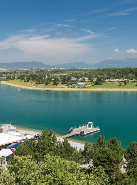 Landscape at Schwarzlsee with water, dock, and greenery. | © Region Graz - Harry Schiffer