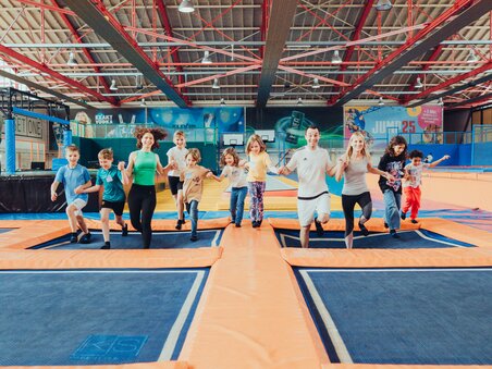A group of children and adults jumping on trampolines. | © Lex Karelly