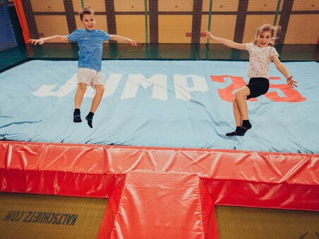 Two kids joyfully jumping on a trampoline with the text JUMP25. | © Lex Karelly