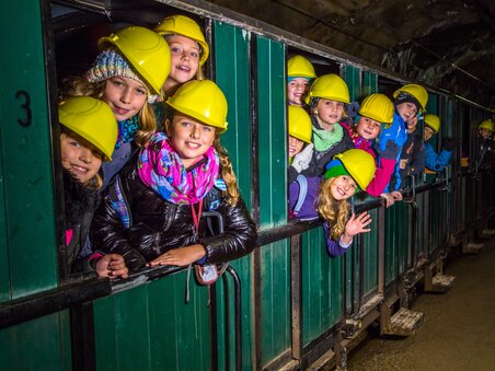 Group of children wearing safety helmets at the Erzberg mine. | © VA Erzberg - Fotograf August Zöbl