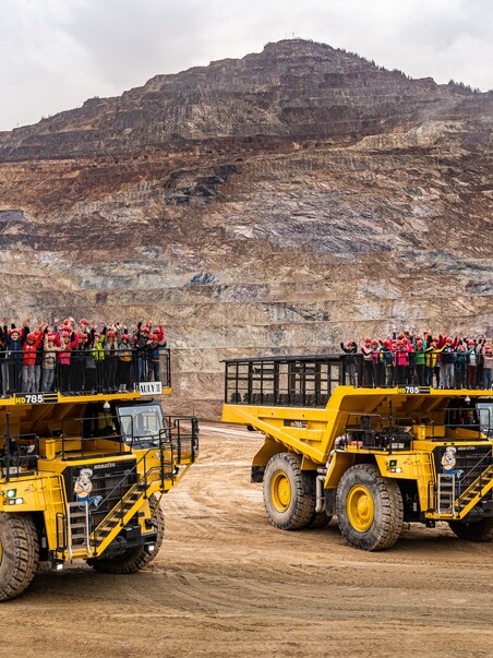 Two massive dump trucks with people on the loading platforms at Erzberg. | © Harald Tauderer