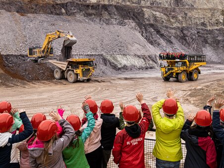 A group of children with helmets watching heavy machinery at Erzberg. | © Harald Tauderer
