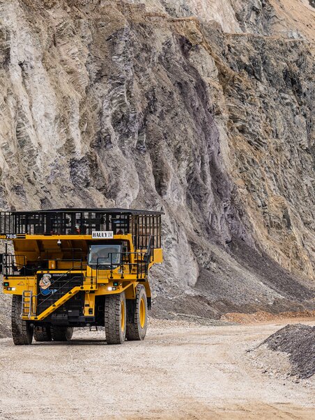 Two large dump trucks on a gravel road in the ore yard. | © Harald Tauderer