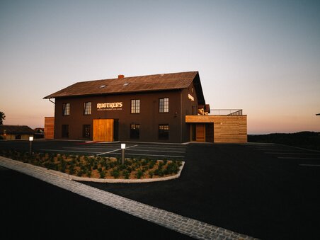 A stylish building with wood and stone accents at dusk. | © David Gölles