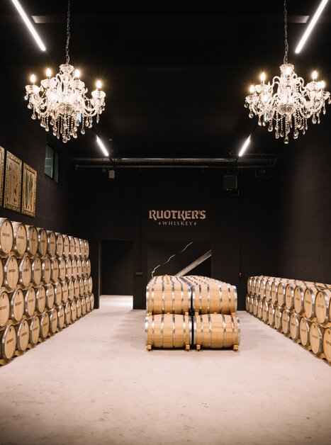 Interior view of a whiskey storage with barrels and chandeliers. | © David Gölles